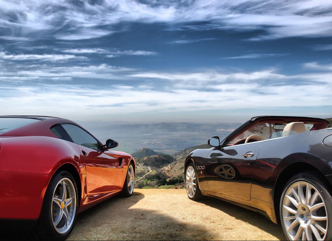 Service Center - Two Luxury Sports Cars Parked on Top of a Scenic Overlook with Views of the Mountains and Cloudy Sky